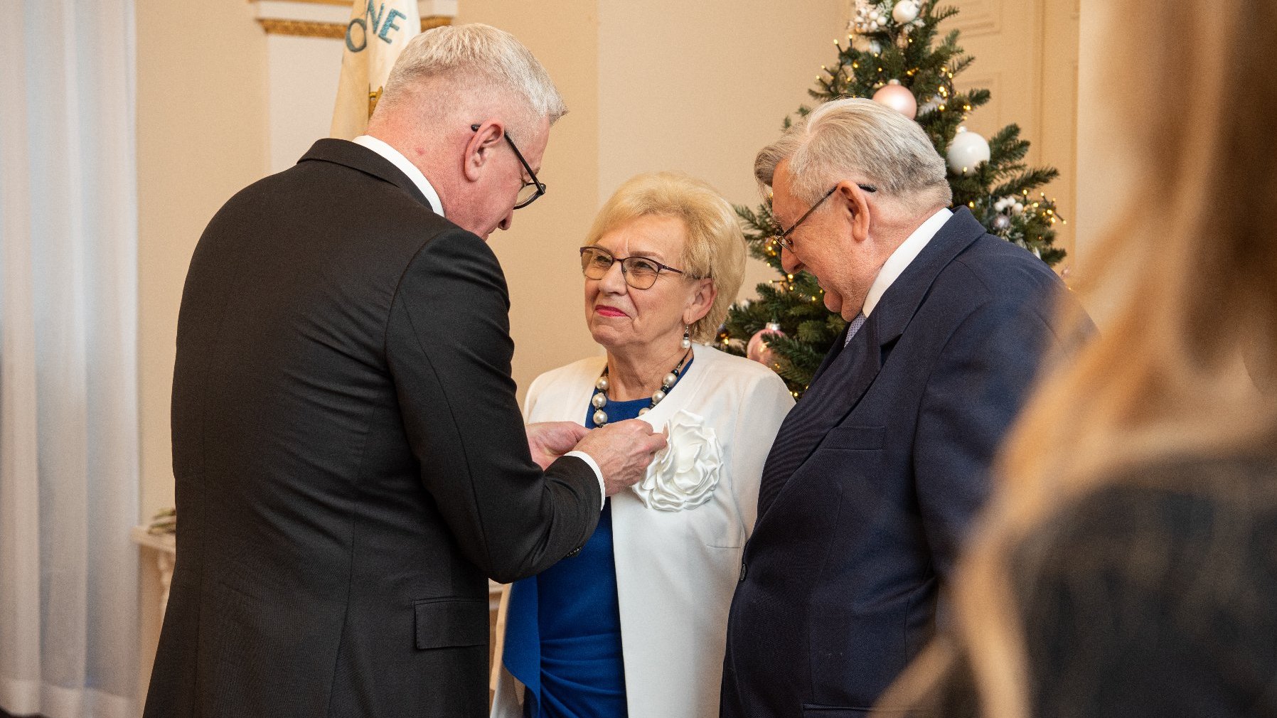 Na zdjęciu prezydent Poznania przypinający medal kobiecie