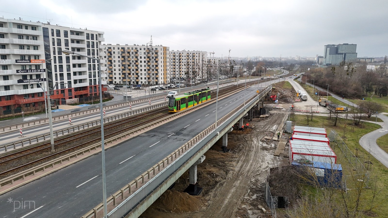 Widok na wiadukt na ul. Hetmańskiej i sąsiednie bloki, wiaduktem jedzie tramwaj. Pod wiaduktem trwają prace remontowe.