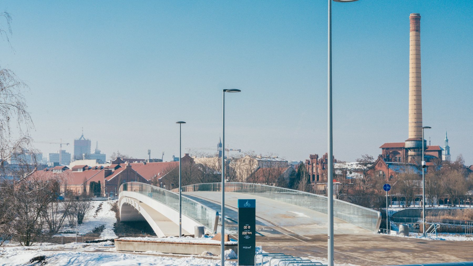 Widok na most od strony Ostrowa Tumskiego, w tle zabudowa centrum miasta, po prawej wysoki komin