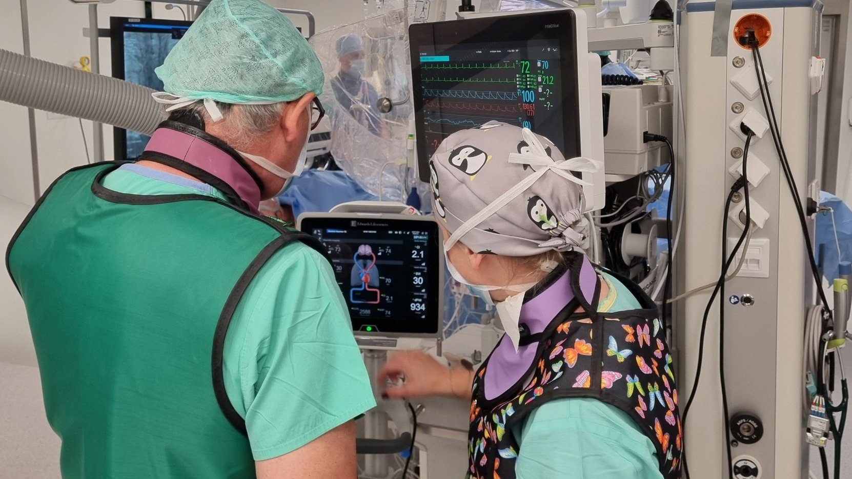 Zdjęcie przedstawia lekarzy przy sprzęcie na sali operacyjnej.