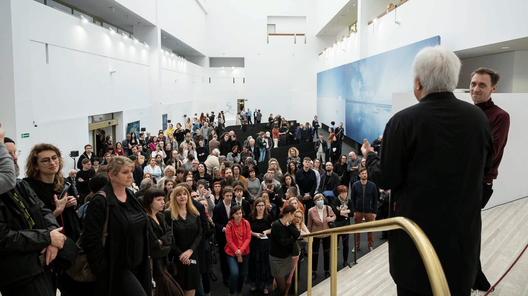 Galeria zdjęć przedstawia grupę ludzi stojąch w przestrzeni wystawienniczej w Muzeum Narodowym w Poznaniu.