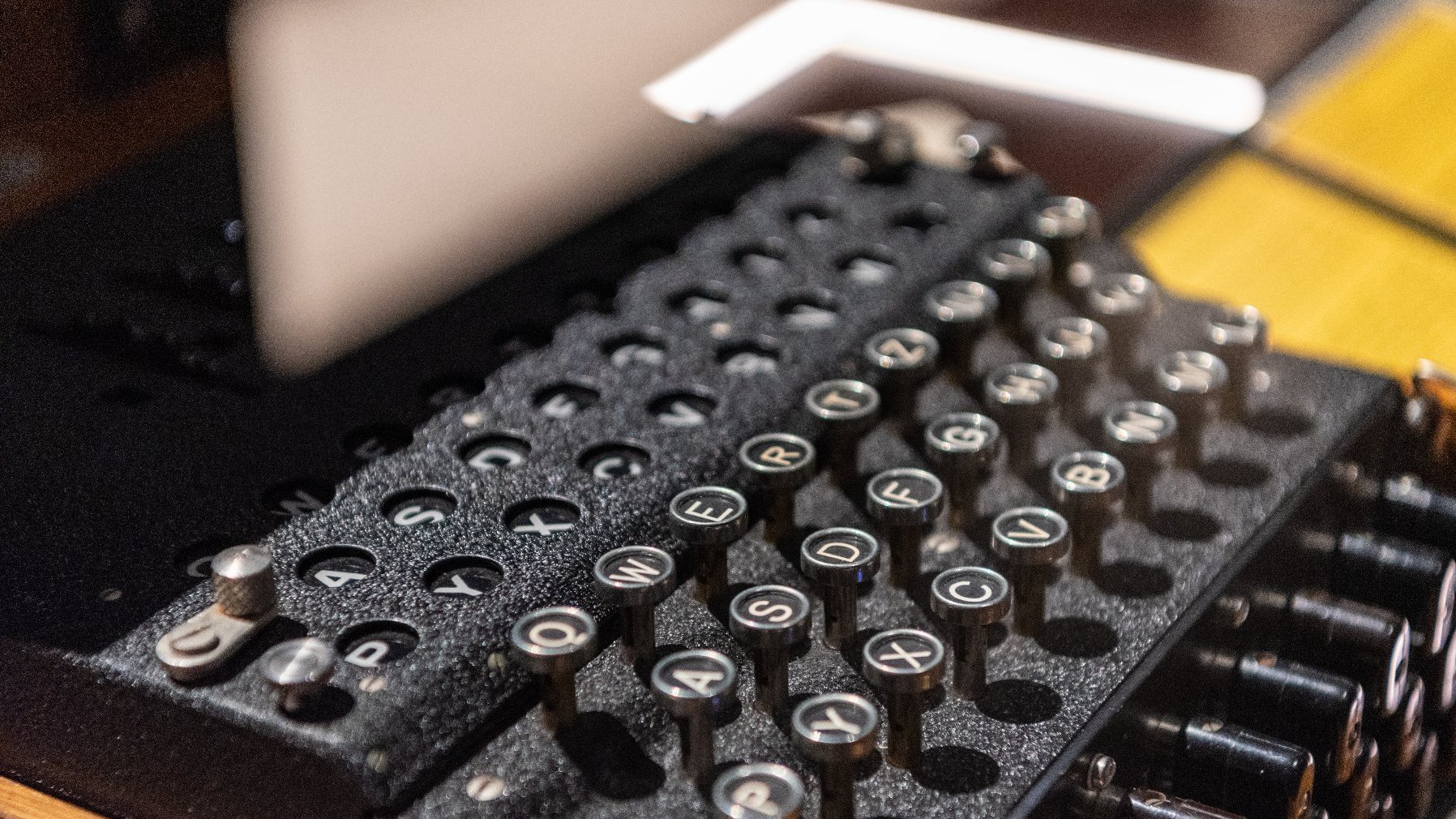 Zdjęcie przedstawia zbliżenie na klawiaturę niemieckej maszyny szyfrującej Enigma.