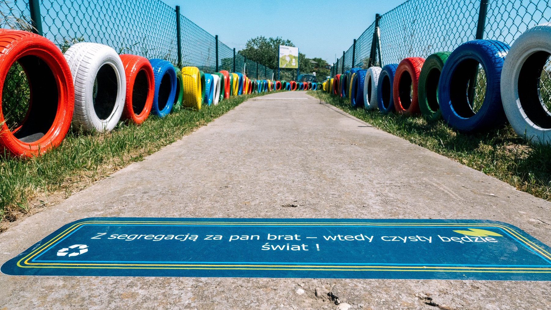 Na zdjęciu ścieżka edukacyjna, po jej obu stronach kolorowe opony
