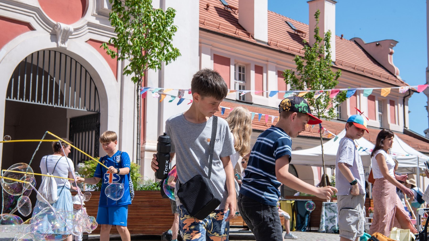 Na zdjeciu dzieci puszczające bańki mydlane