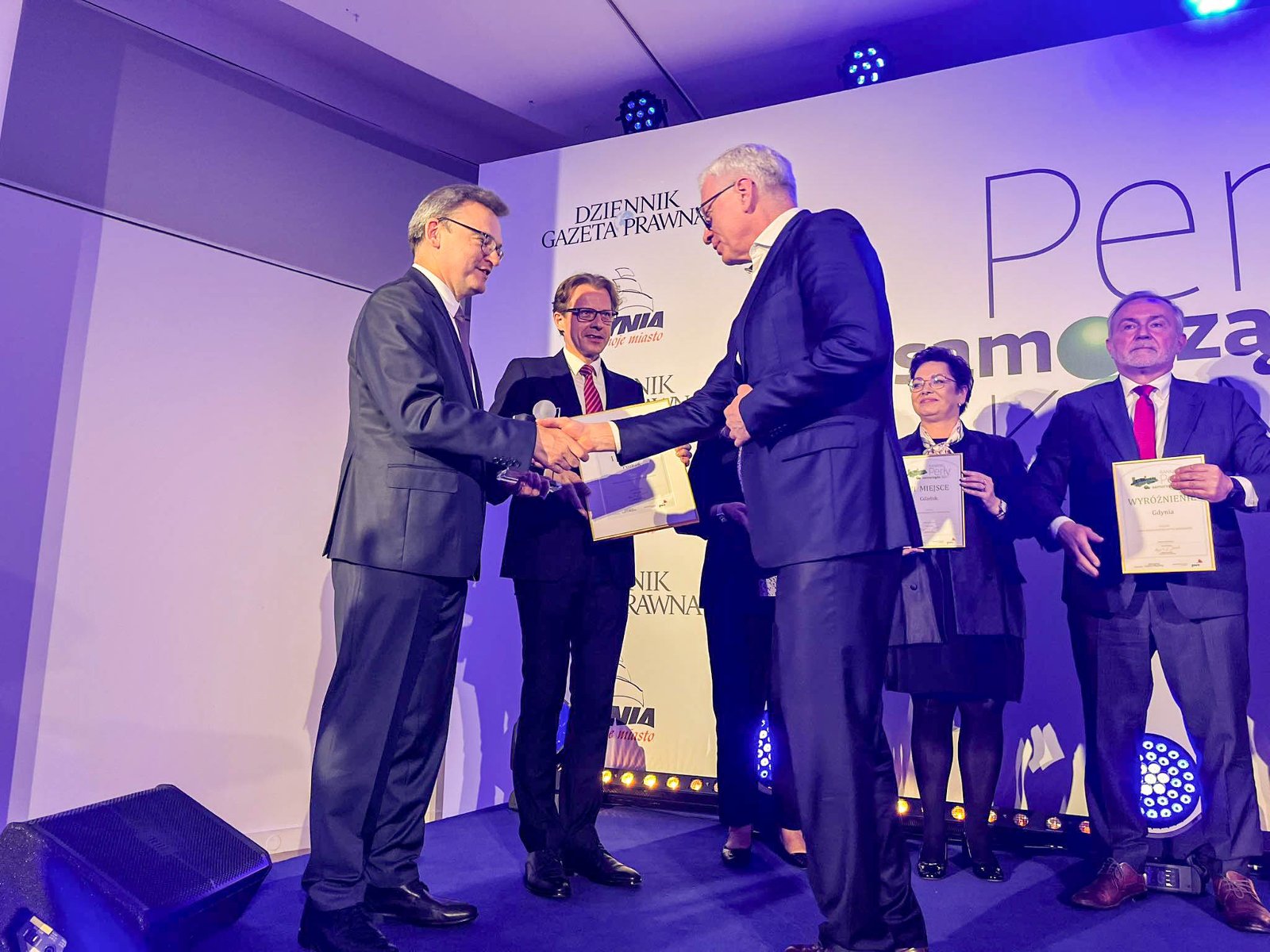 Na zdjęciu prezydent Poznania odbierający nagrodę na scenie - grafika artykułu