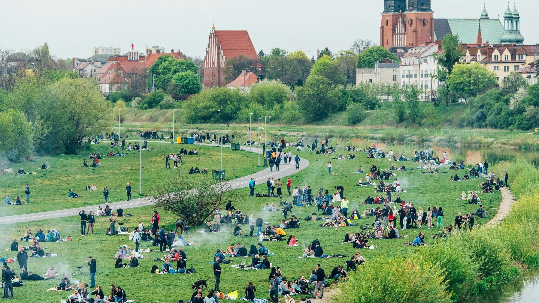 Galeria zdjęć przedstawia ludzi wypoczywającyc nad Wartą. W tle katedra na Ostrowie Tumskim.