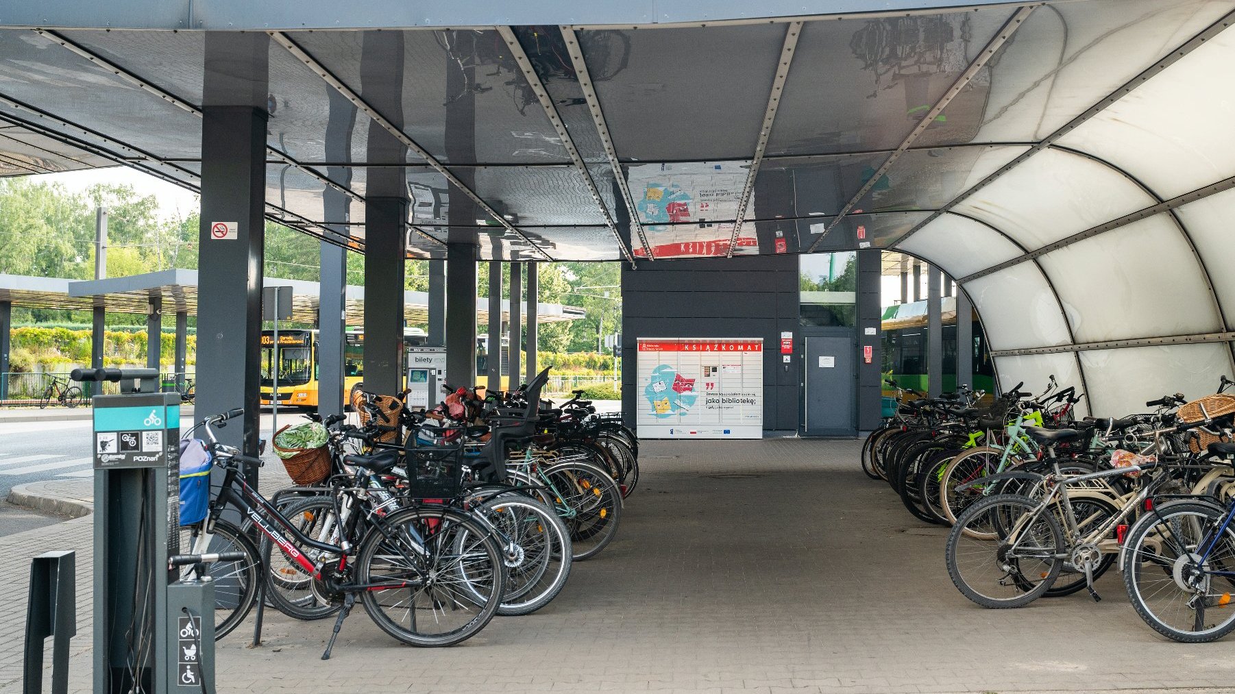 Na zdjęciu parking dla rowerów, w tle stoi autobus