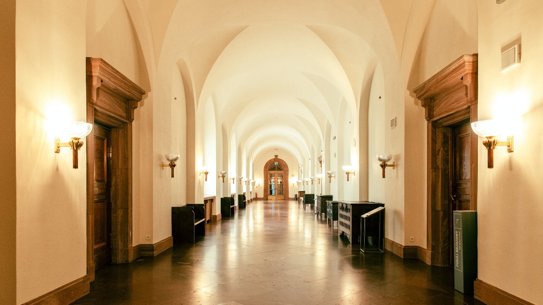 Na zdjęciu korytarz zamku, oświetlony lampami
