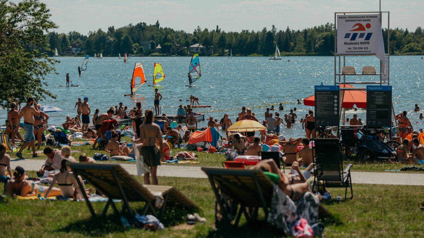 Na zdjęciu tłum ludziplazujących nad brzegiem jeziora - grafika artykułu