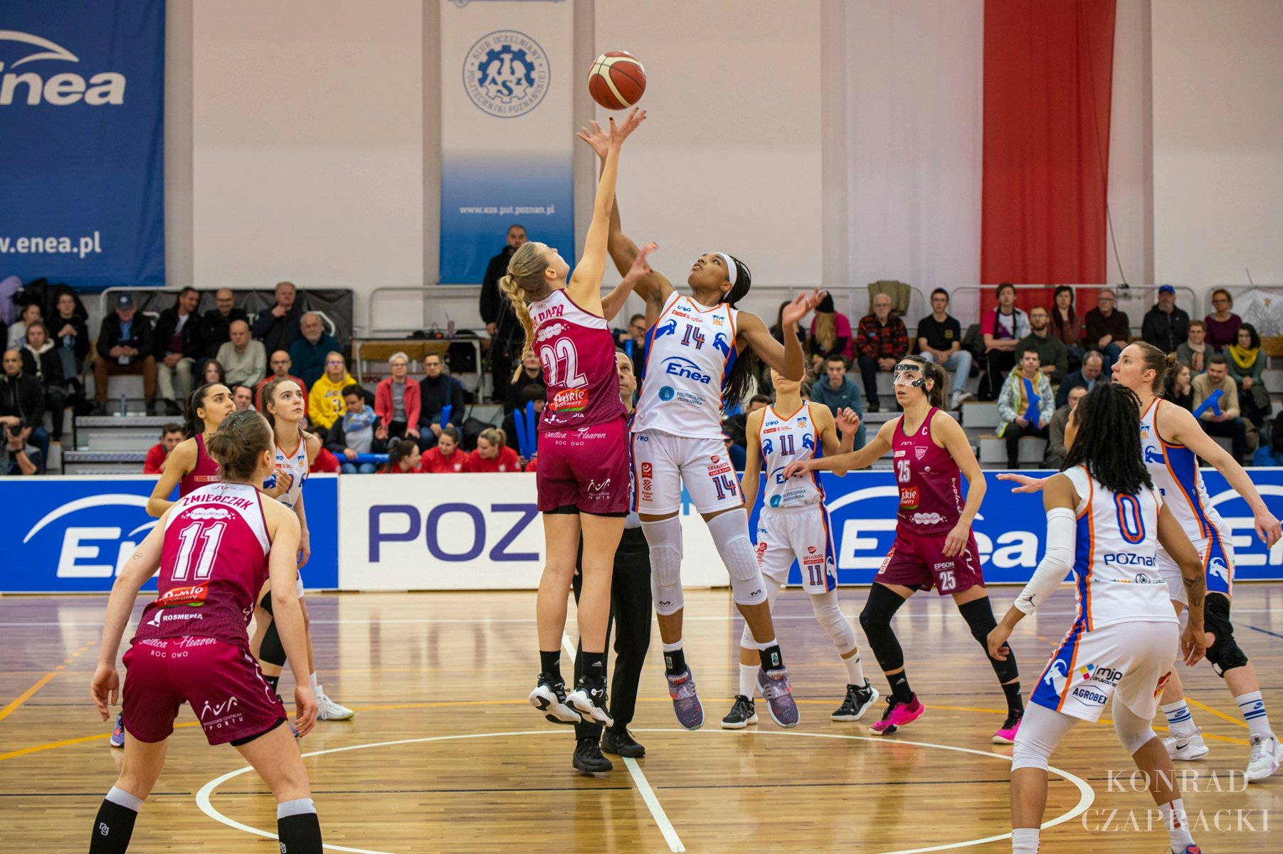 Zdjęcie przedstawia mecz koszykówki kobiet. Na środku kadru widać dwie zawodniczki walączce o piłkę. - grafika artykułu