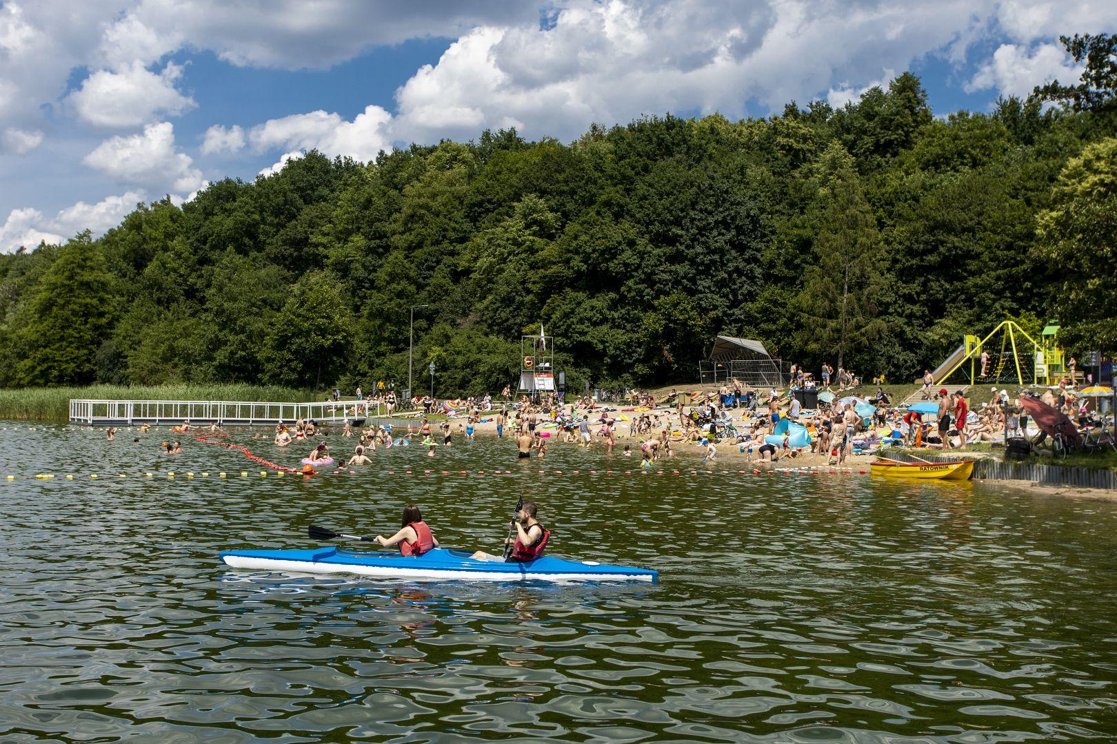 Na zdjęciu widok na plażę, na której znajduje się tłum ludzi kąpiących sie i plazujących - grafika artykułu