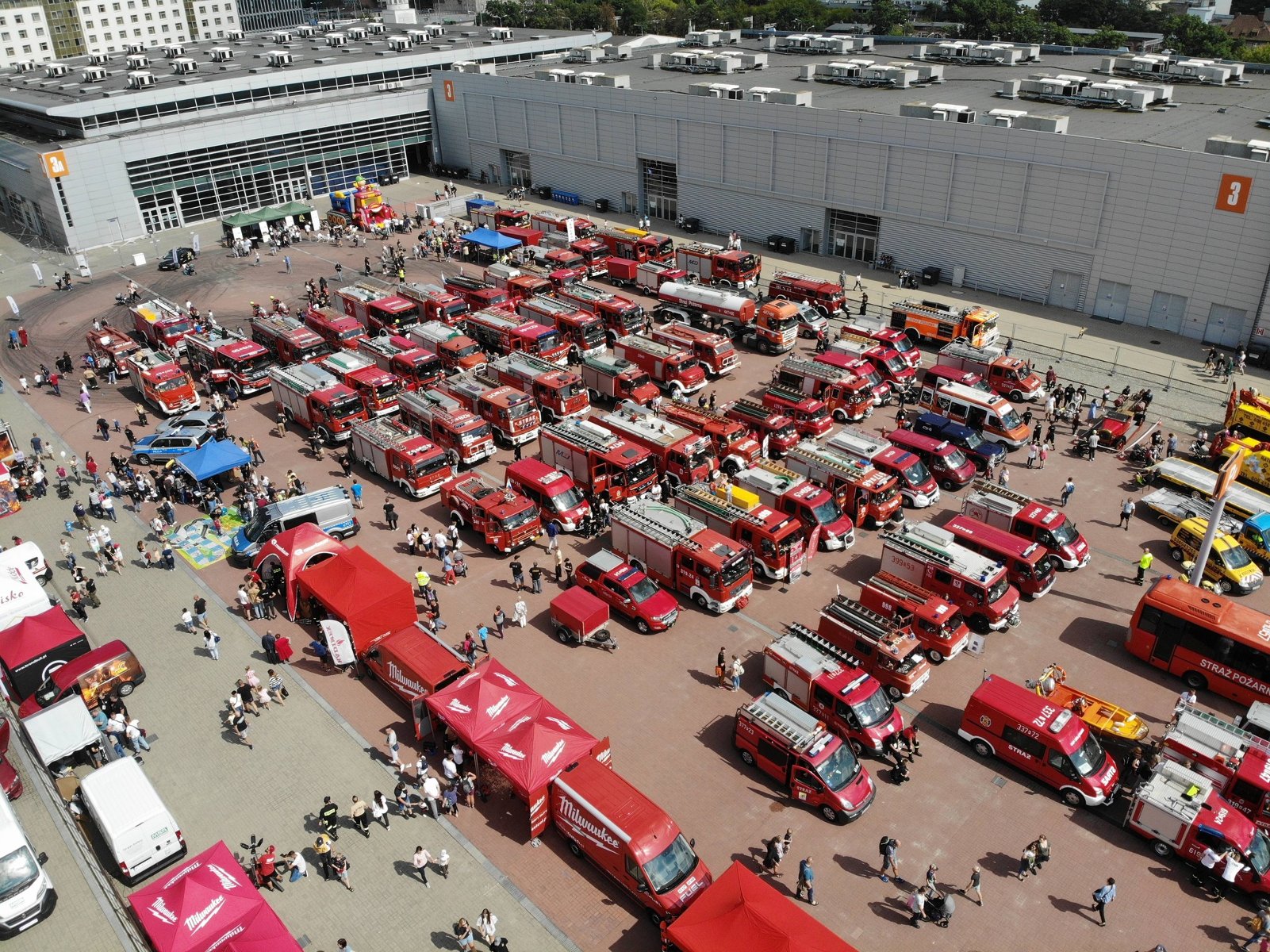Na zdjęciu widok z góry na plac, na którym stoi mnóstwo czerwonych samochodów - grafika artykułu
