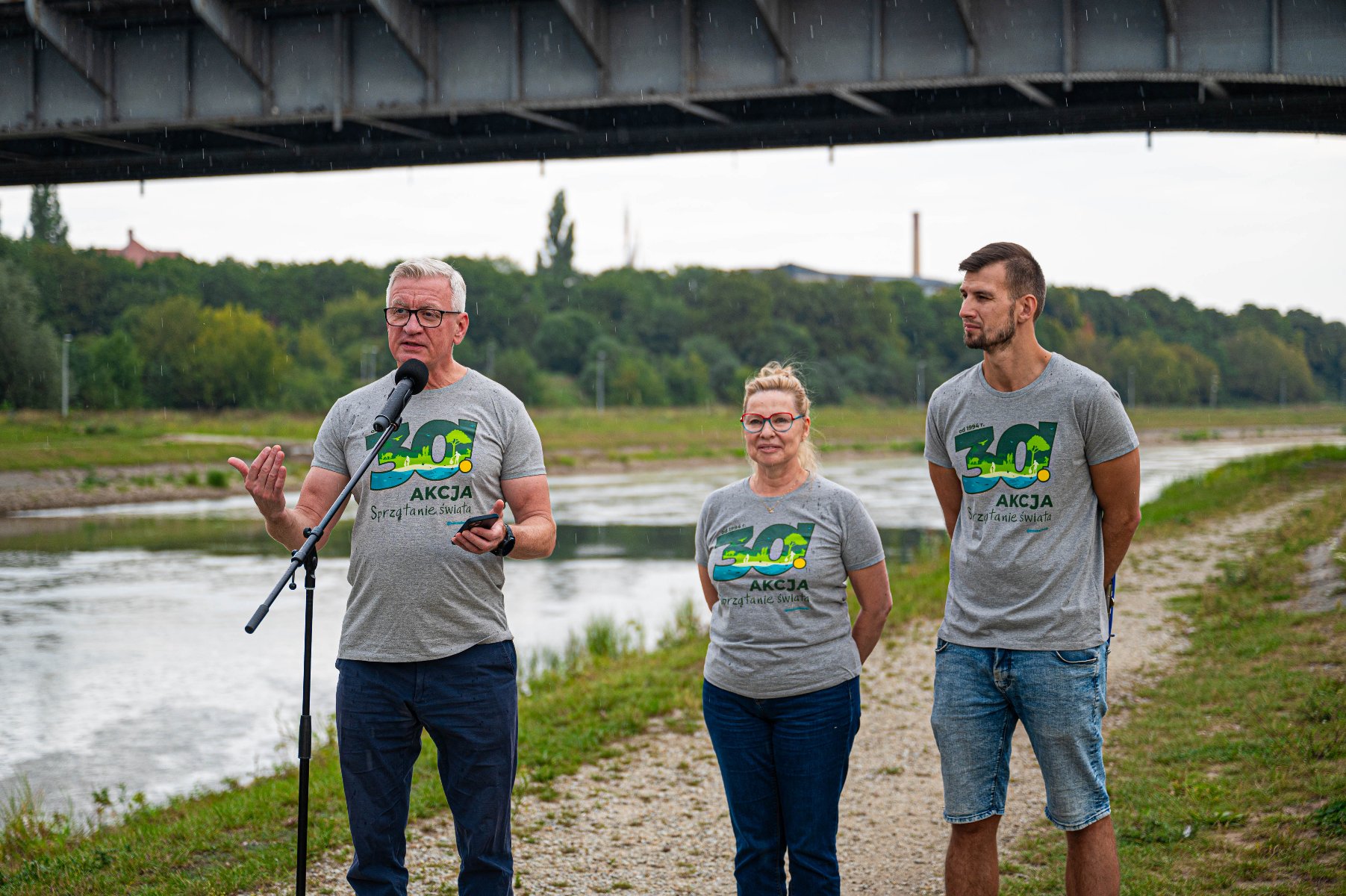 Na zdjęciu konferencja prasowa, przed mikrofonem trzy osoby, prezydent Poznania coś mówi - grafika artykułu