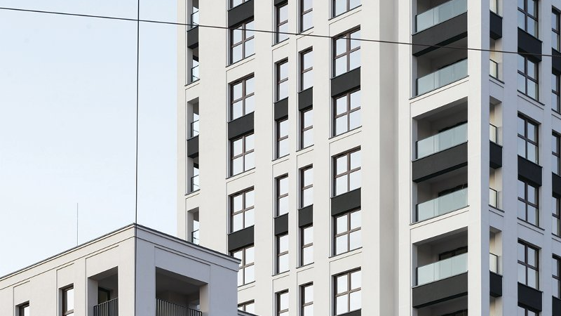 Zdjęcie przedstawia kilkunastokondygnacyjny budynek "Famma" o jasnej elewacji z rytmicznym podziałem okien.