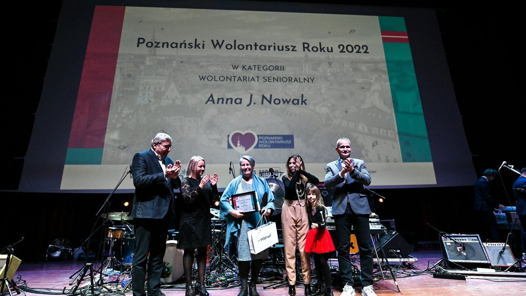 Galeria zdjęć przedstawia osoby stojące na scenie podczas wręczania nagród w ramach konkursu Poznański Wolontariusz Roku 2022.