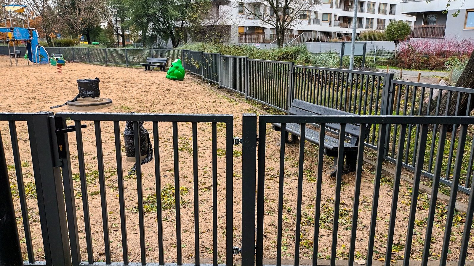 Na zdjęciu plac zabaw ogrodzony nowym płotem