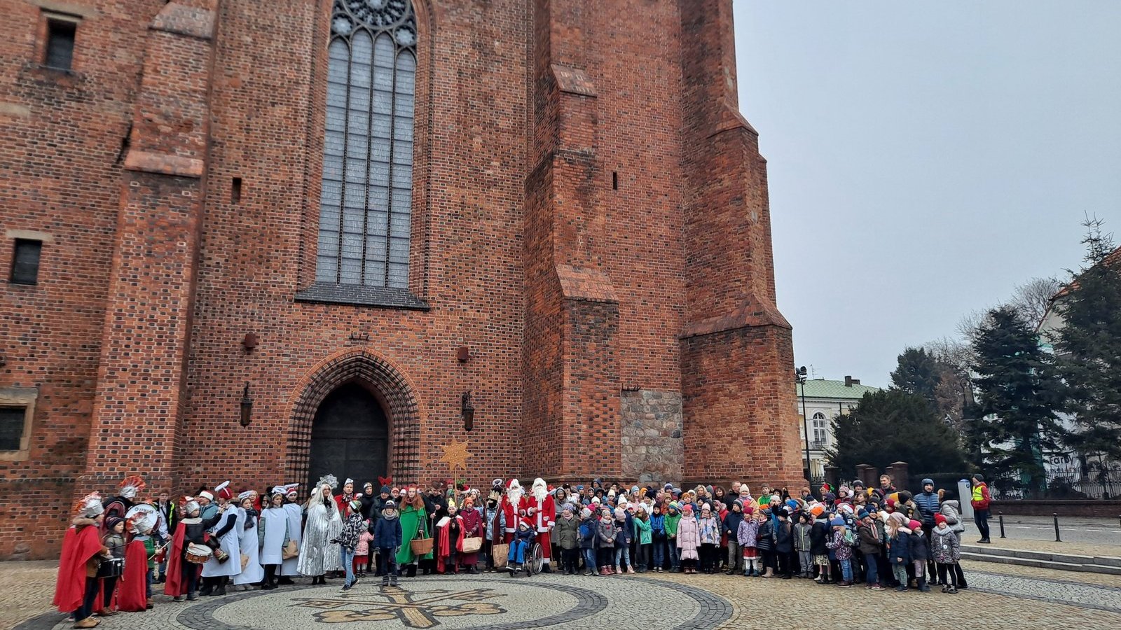 Zdjęcie przedstawia grupowe zdjęcie uczestników marszu przed poznańską katedrą.