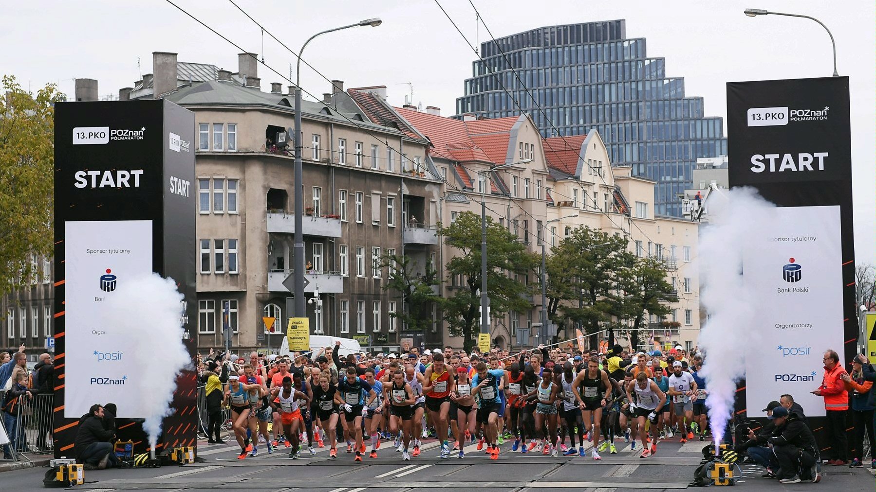 Zdjęcie przedstawia grupę startujących do biegu sportowców. W tle widać kamienice i biurowiec Bałtyk. - grafika artykułu