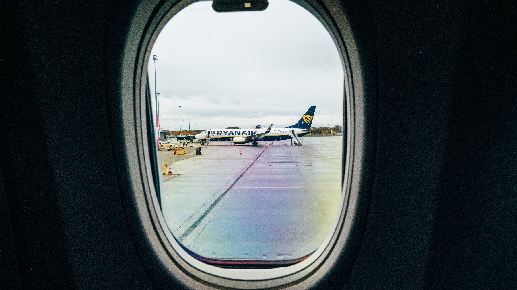 Widok z okienka samolotu na samolot Ryanair stojący na płycie lotniska