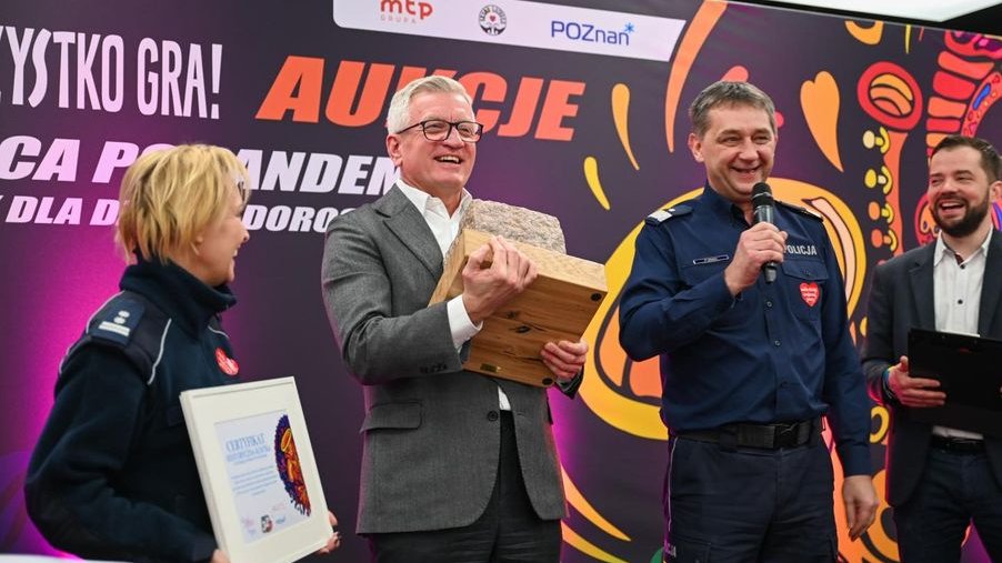 Prezydent Jacek Jaśkowiak trzymający kamienną kostkę