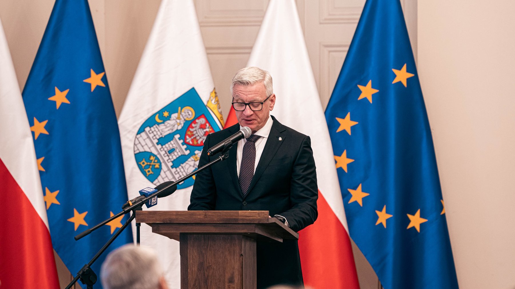 Na zdjęciu prezydent Poznania przy mównicy, czytający laudację