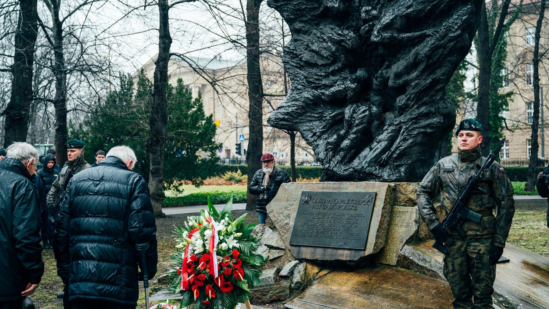 Na zdjęciu pomnik, pod nim kwiaty, obok żołnierz na warcie