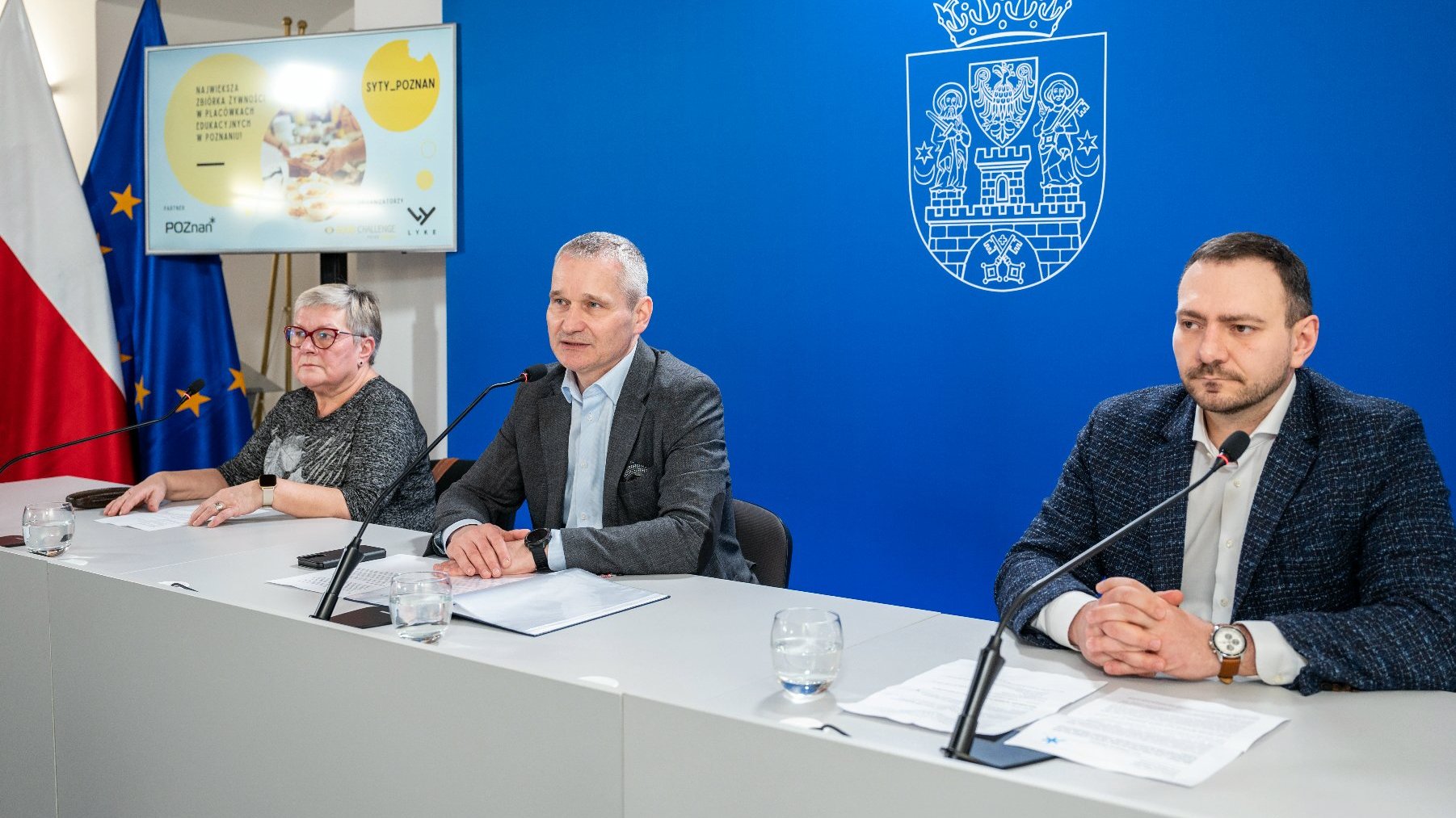 Na zdjęciu trzy osoby, dwóch mężczyzn i kobieta, za stołem konferencyjnym