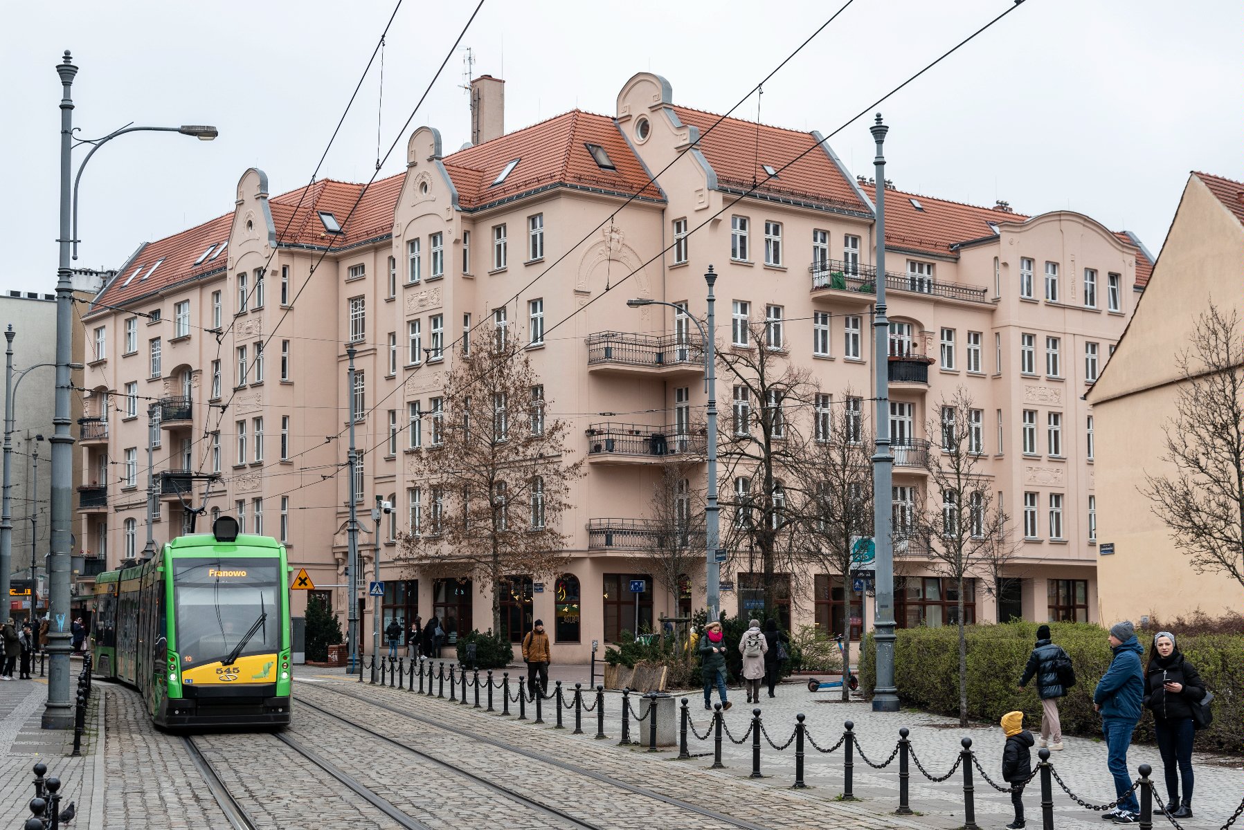 na zdjęciu kamienica ZKZL przy ul. Wrocławskiej, widać budynek, przejeżdżający obok niego tramwaj i przechodniów - grafika artykułu