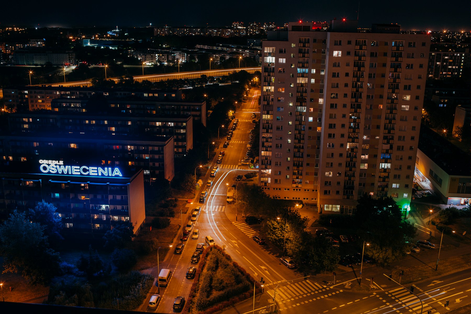 Zdjęcie przedstawia bloki na Ratajach widziane z lotu ptaka nocą. - grafika artykułu