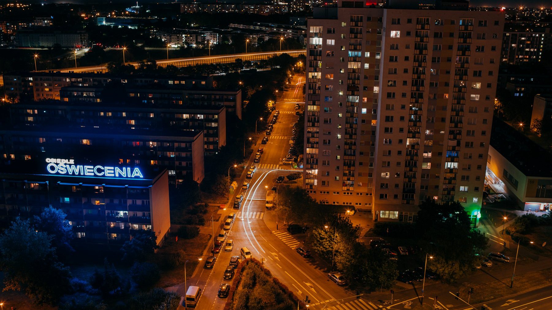Zdjęcie przedstawia bloki na Ratajach widziane z lotu ptaka nocą.