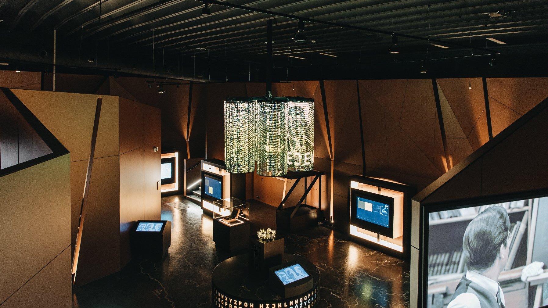 Na zdjeciu wnętrze Centrum Szyfrów Enigma, widać ekrany i wielką lampę