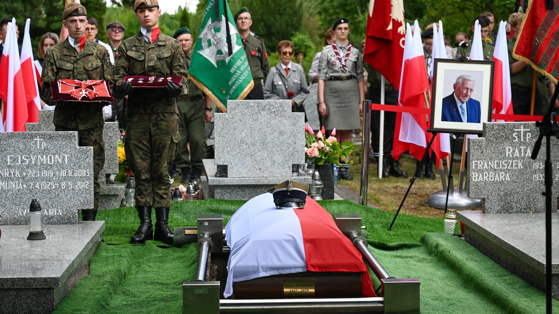 Na zdjęciu trumna nakryta flagą, obok żołnierze