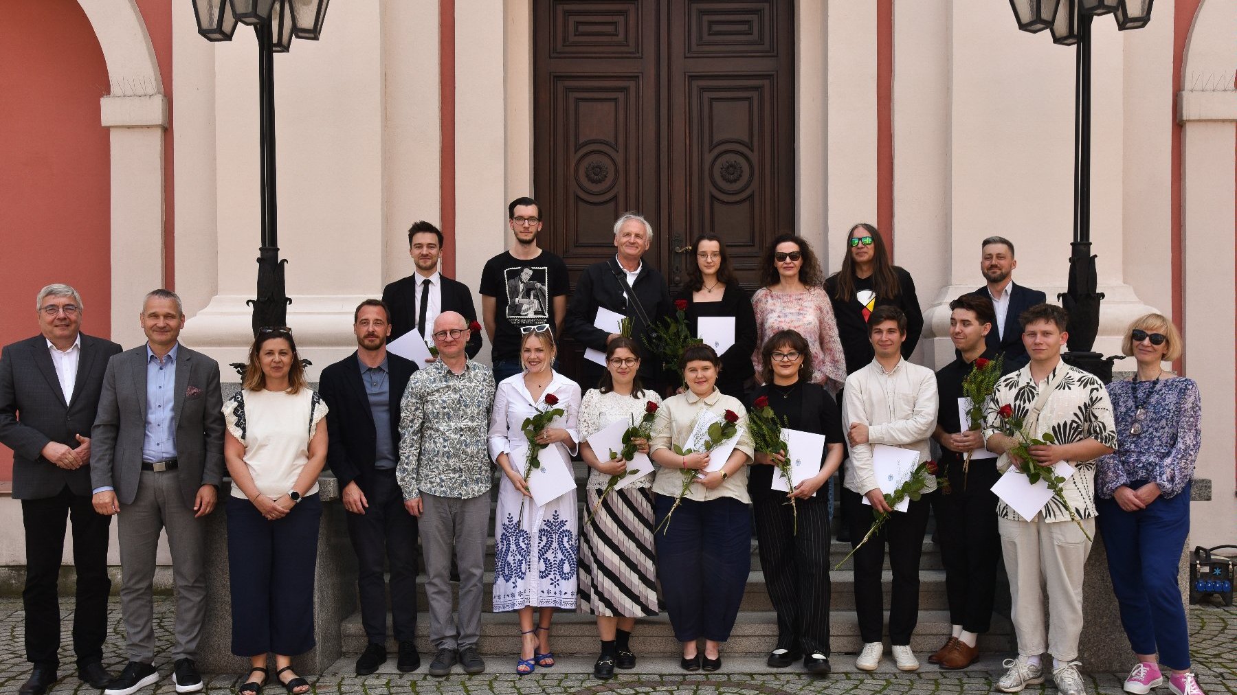 Na zdjęciu grupa ludzi przed urzędem, pozująca do obiektywu - zdjęcie grupowe