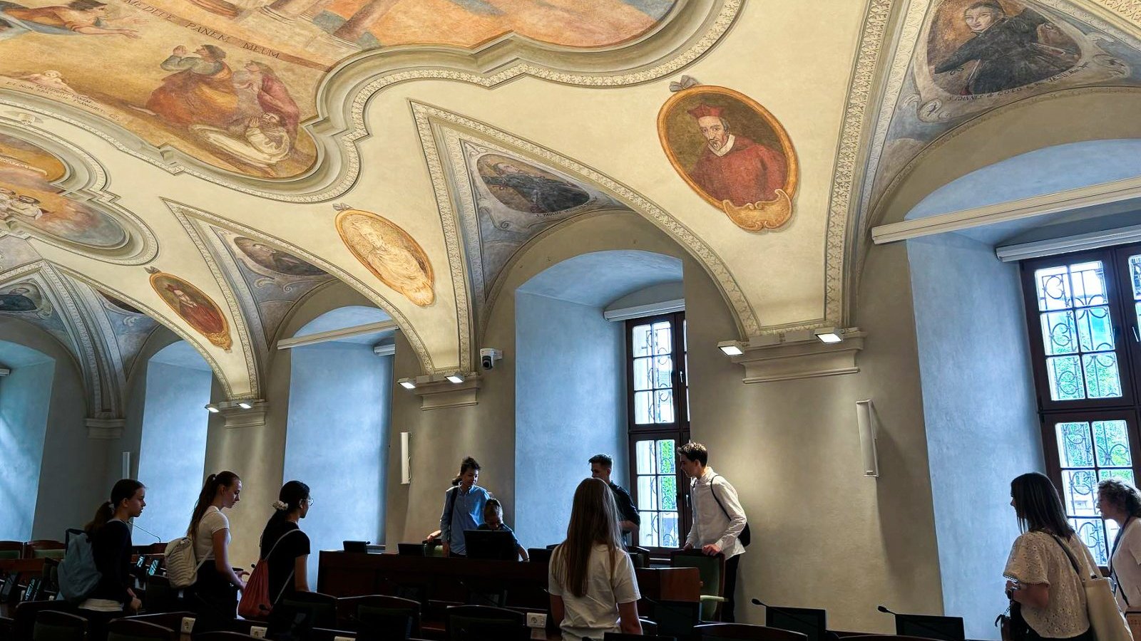 Na zdjęciu uczniowie w sali sesyjnej, oglądający freski