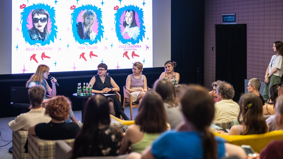 Zdjęcie przedstawia cztery kobiety podczas panelu dyskusyjnego - siedzą na krzesłach, słuchają ich inni ludzie.