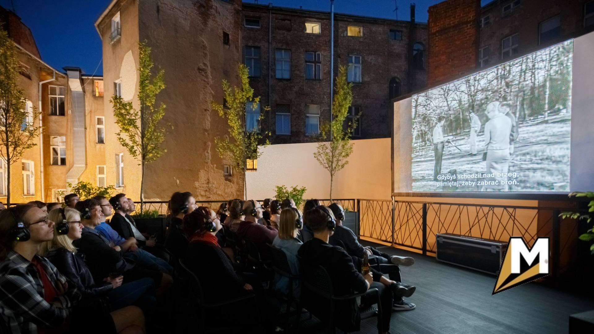 Na zdjęciu widzowie na tarasie, oglądający film na dużym ekranie