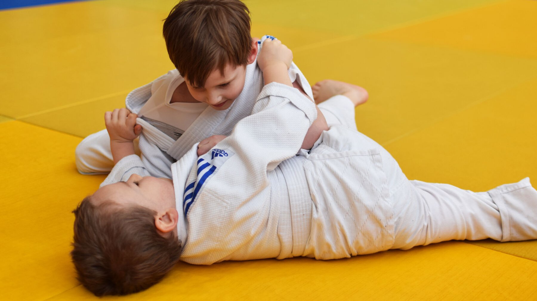 chłopcy w białych judogach podczas walki