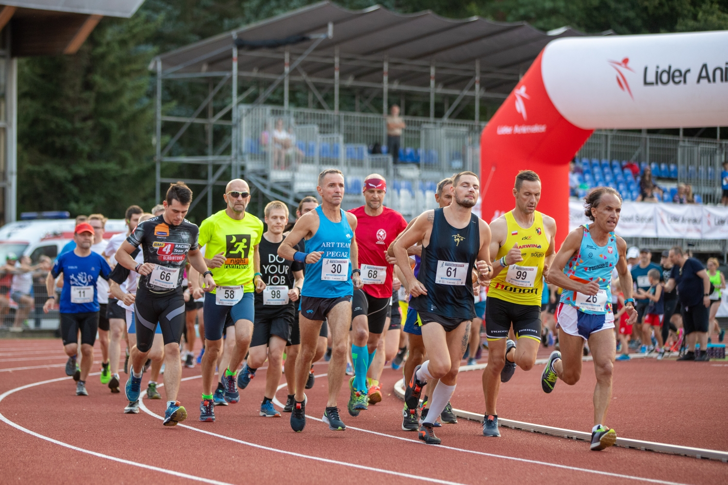 zawodnicy biegnący na wirażu stadionu lekkoatletycznego - grafika artykułu