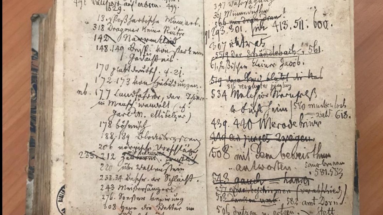 photo of an open old damaged book with visible handwritten notes