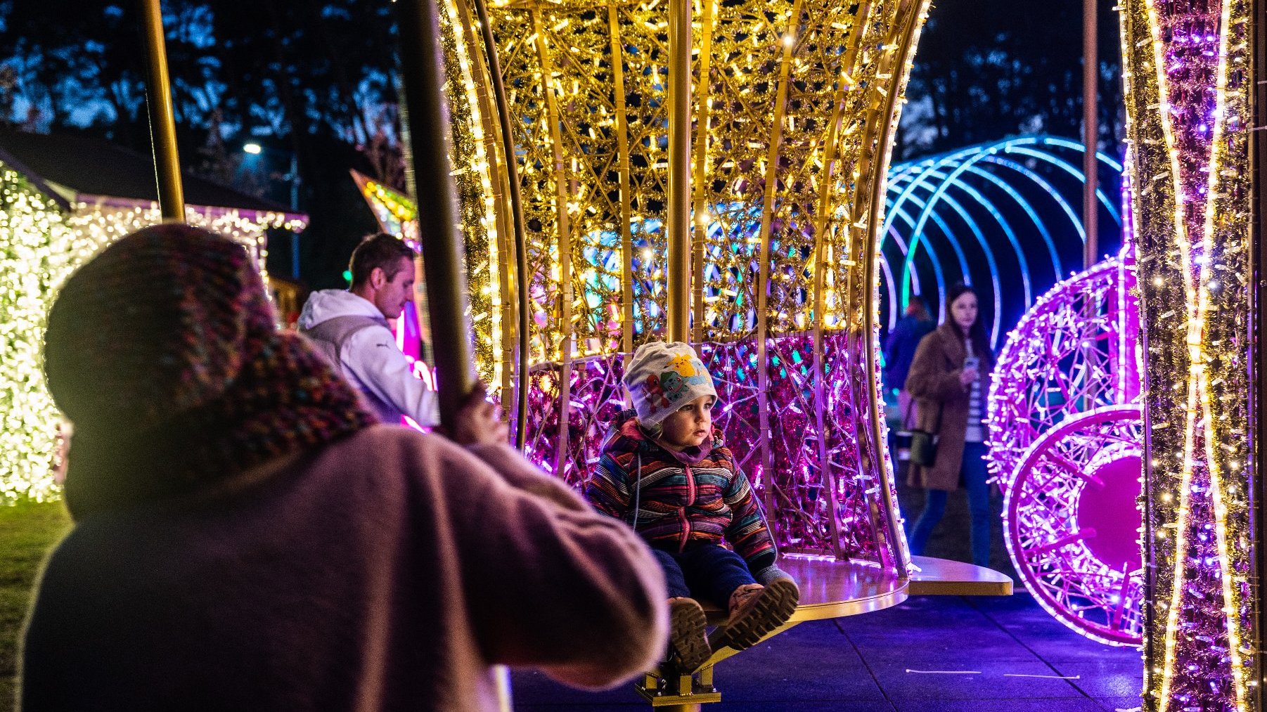 Galeria zdjęć przedstawia iluminacje świetlne i oglądających je ludzi.