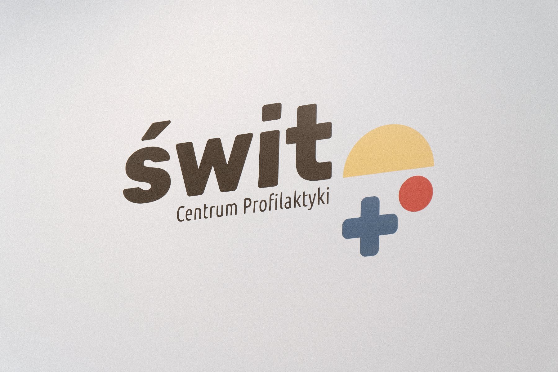 Logo Centrum Profilaktyki Świt przedstawiające wschodzące słońce - u góry większe żółte półkole, poniżej po prawej stronie mniejsze czerwone kółko i jeszcze niżej po lewej granatowy krzyżyk - podobny do znaku dodawania - grafika artykułu