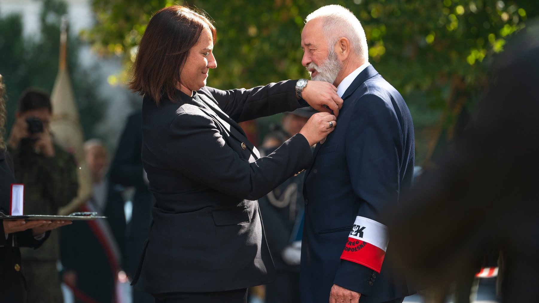 Zdjęcie przedstawia wicewojewode przypominającą medal starszemu mężczyźnie.