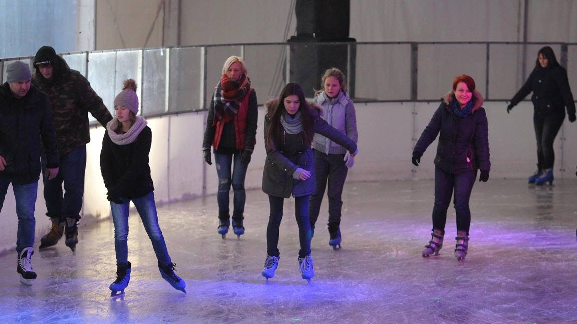 Picture of a skating-rink and several people skating on it