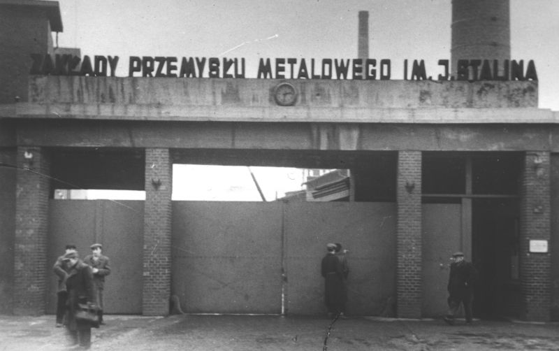 Duża brama wjazdowa. Napis na górze: Zakłady Przemysłu Metalowego im. J. Stalina