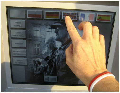 Palec wskazuje wersję językową na ekranie monitora