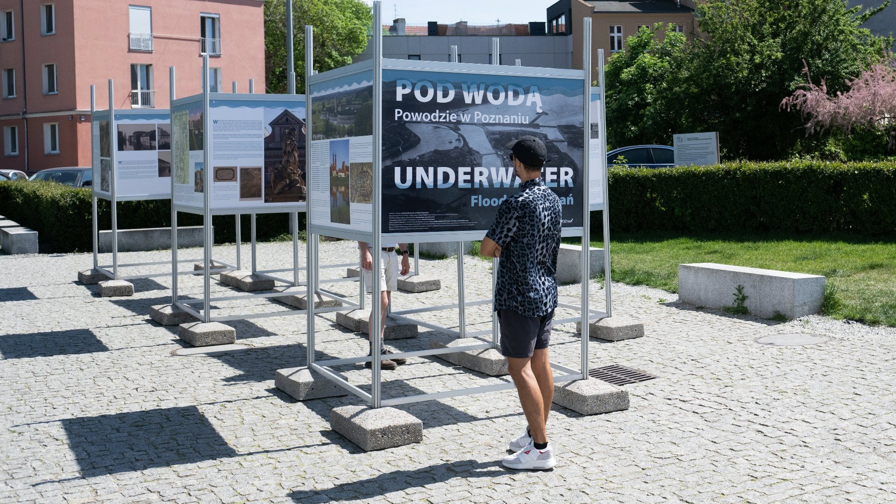 Galeria zdjęć przedstawia ludzi oglądających wystawę "Pod wodą. Powodzie w Poznaniu".