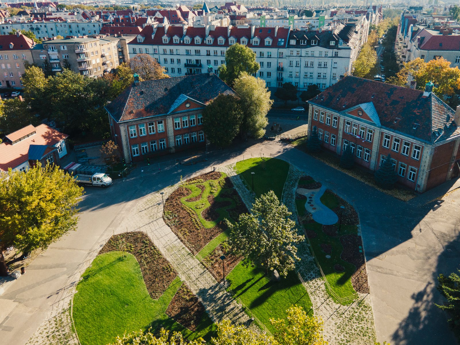 Zdjęcie przedstawia budynki i zieloną przestrzeń z lotu ptaka. - grafika artykułu