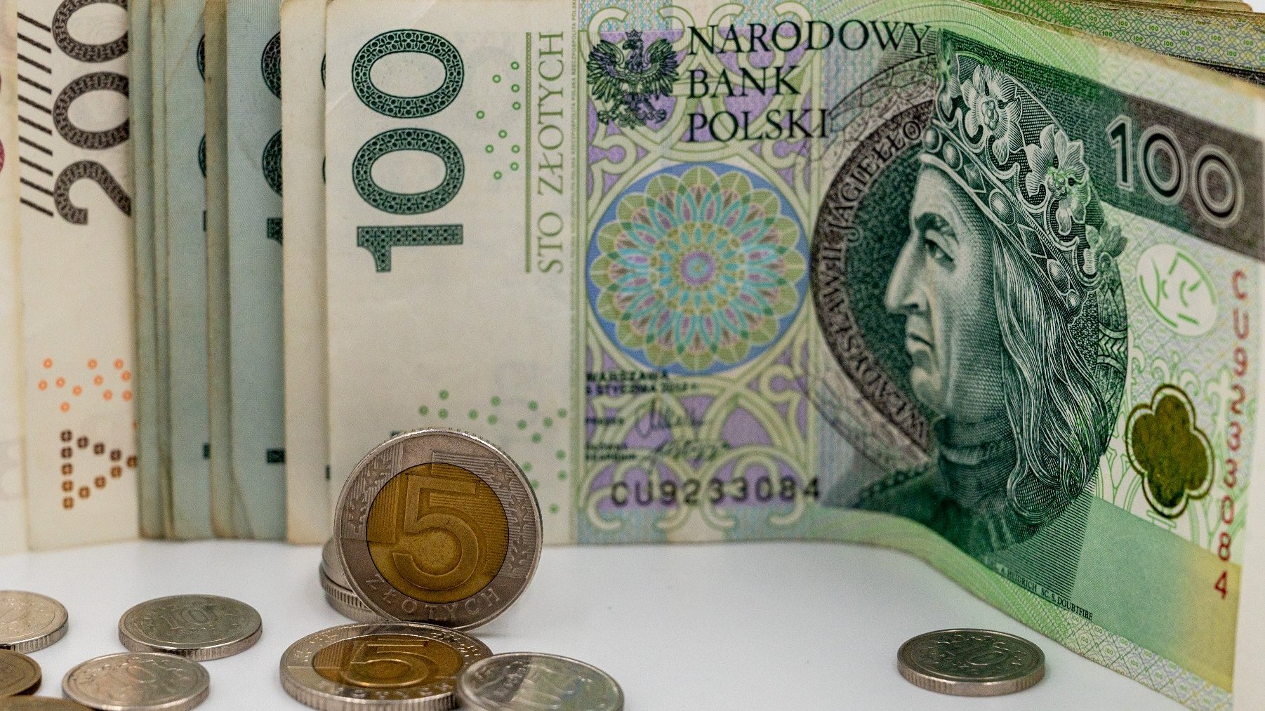 Na zdjęciu banknoty i monety leżące obok siebie