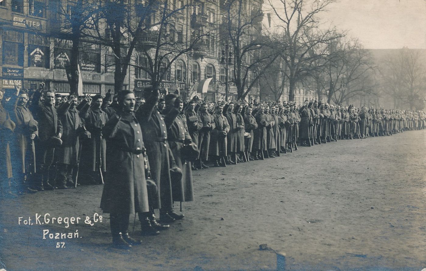 Żołnierze w szeregu, wznoszą dłonie z dwoma palcami w górze, w geście przysięgi - grafika artykułu