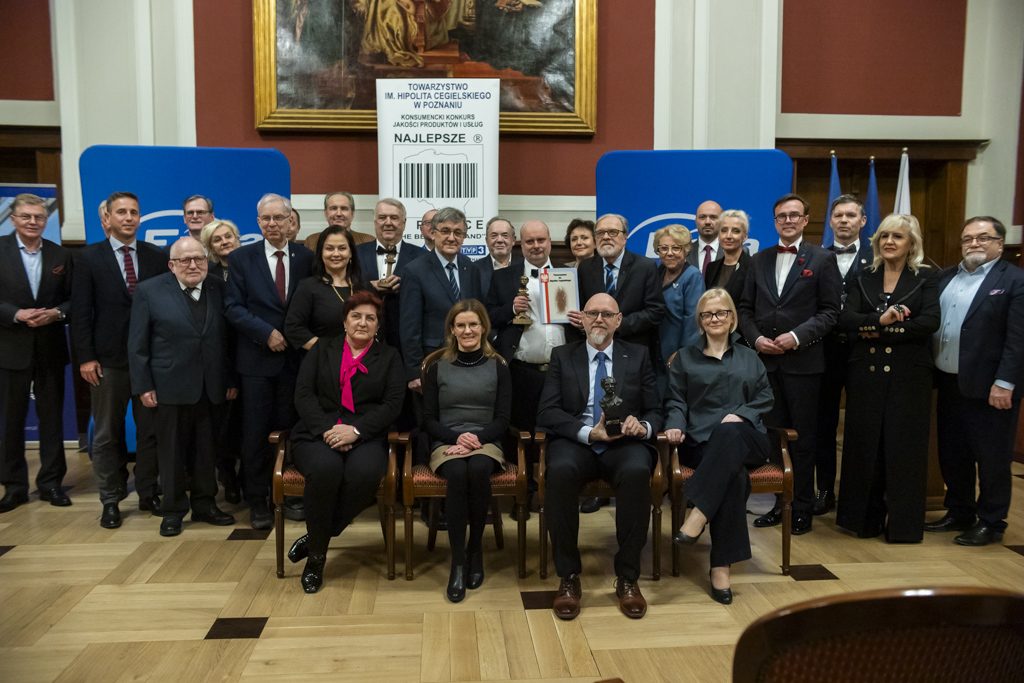 Ludzie siedzący na krzesłach będący laureatami konkursu "Najlepsi w Polsce". Część ludzi trzyma dyplomy. W centralnym miejscu siedzą dyrektor Wydawnicta i jej zastępczyni. - grafika artykułu